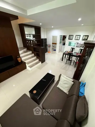 Spacious modern living room with elegant staircase and dining area