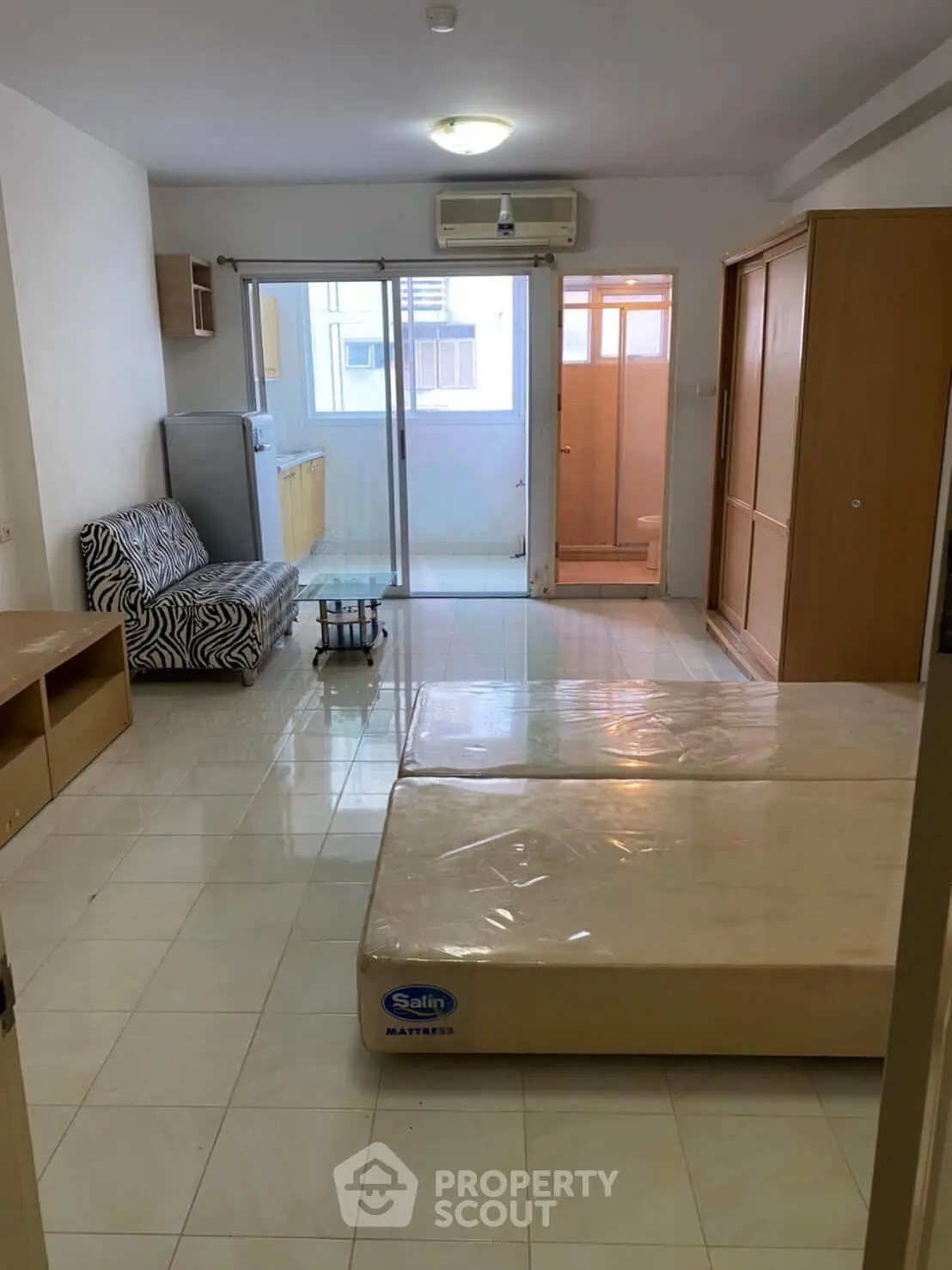 Spacious studio apartment with open layout and natural light, featuring a cozy living area and modern amenities.