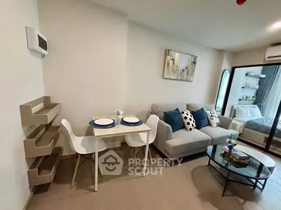 Modern open-plan living room with cozy seating and dining area in stylish apartment.