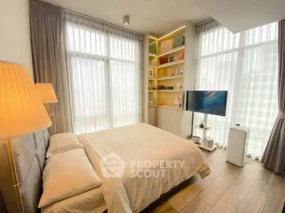Modern bedroom with large windows, stylish decor, and natural light in a high-rise apartment.