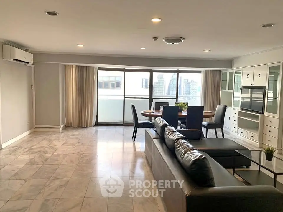 Spacious modern living room with city view, marble flooring, and sleek furniture in a high-rise apartment.