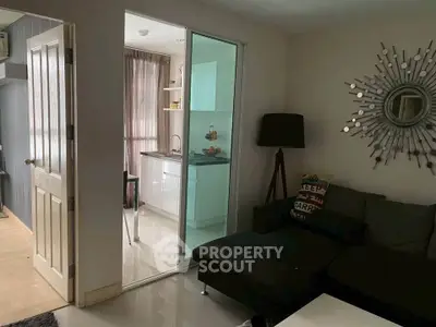 Cozy living room with modern decor and adjacent kitchen in stylish apartment.