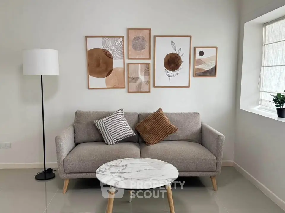 Stylish living room with modern sofa, artistic wall decor, and elegant marble coffee table.