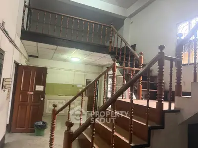 Charming interior staircase with wooden railings in a spacious home, showcasing classic architectural design.