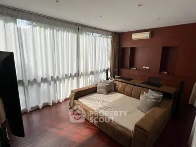 Spacious living room with large windows and modern furniture