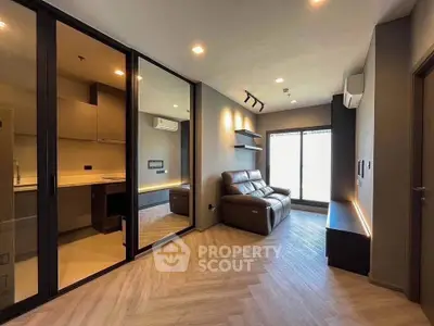 Modern living room with sleek design, glass partition, and cozy seating area.