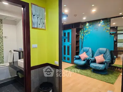 Stylish living room with vibrant colors and cozy seating next to a modern bathroom.