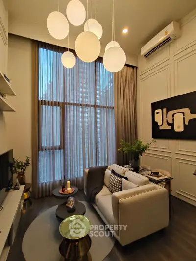 Elegant living room with high ceilings and modern decor, featuring a cozy sofa and stylish lighting.