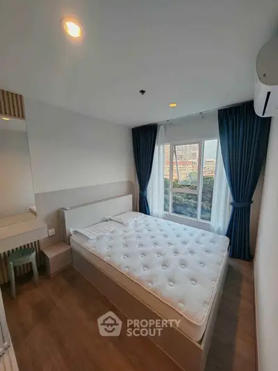Modern bedroom with large window and stylish decor in a high-rise apartment.