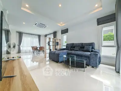 Spacious modern living room with elegant blue sofa and large windows