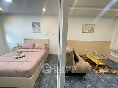 Modern bedroom and living room with stylish decor and cozy ambiance.