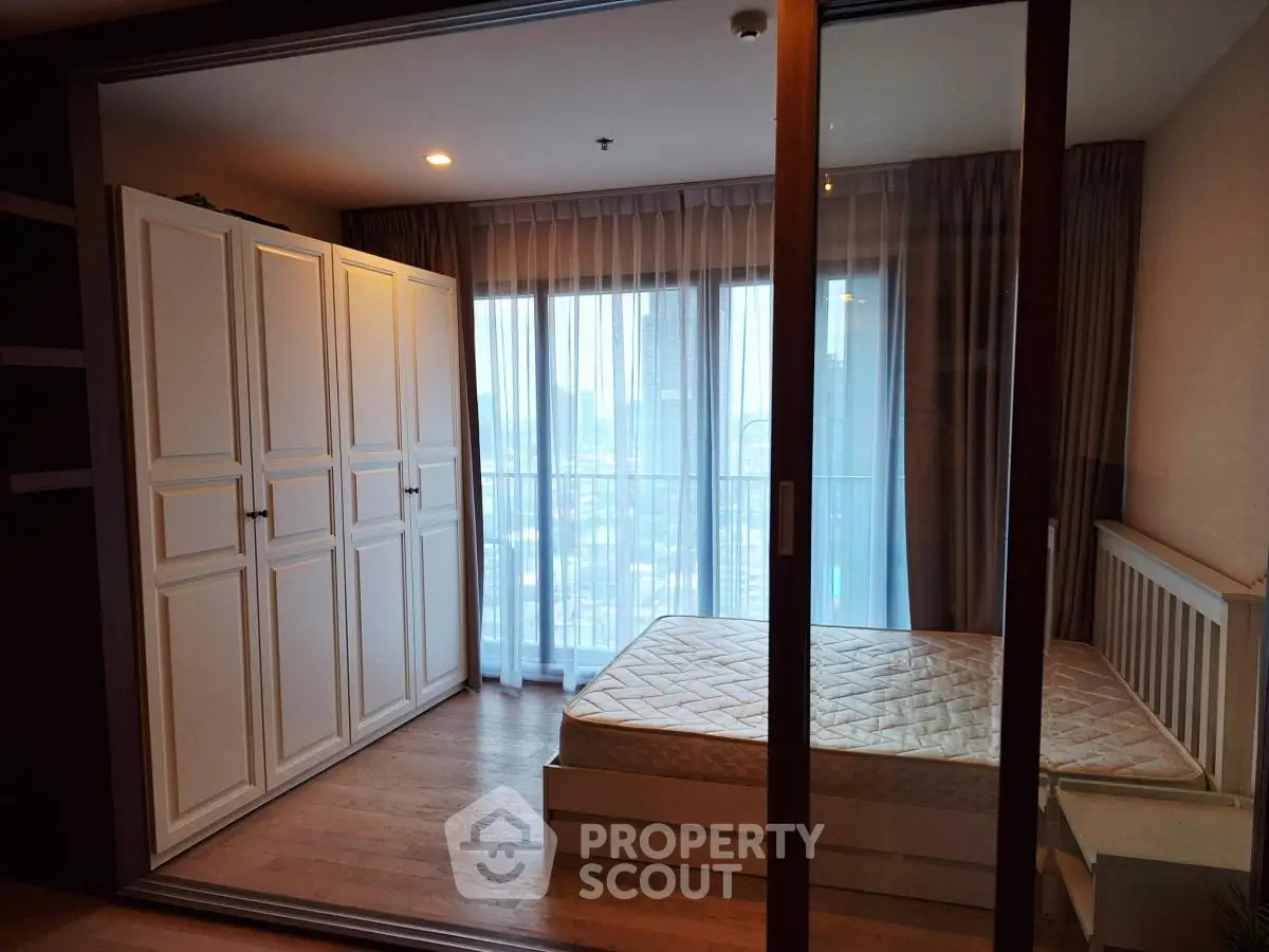 Spacious bedroom with large wardrobe and city view, perfect for urban living.