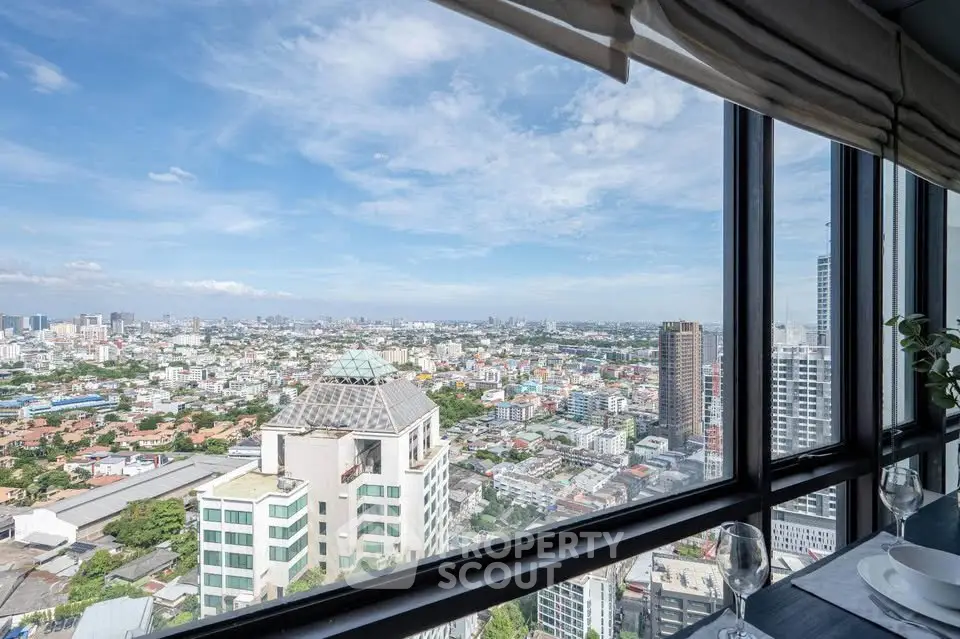 Stunning cityscape view from high-rise apartment window with clear skies and urban skyline.