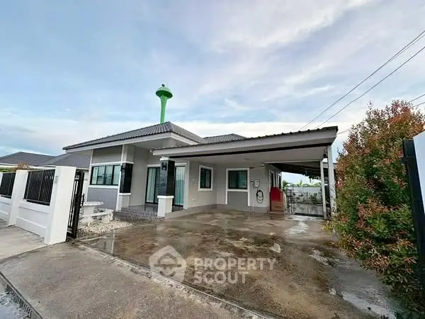 Modern single-story house with spacious driveway and contemporary design.