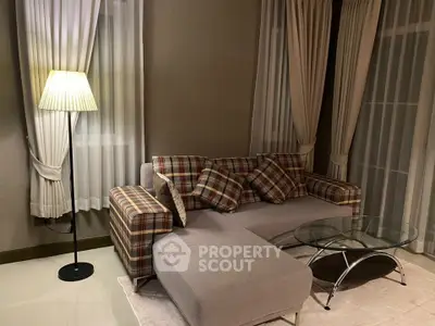 Cozy living room with plaid sofa and elegant floor lamp, perfect for relaxation.