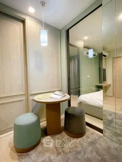 Chic modern bedroom with cozy seating area and mirrored closet doors