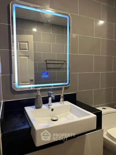 Modern bathroom with illuminated mirror and sleek sink design