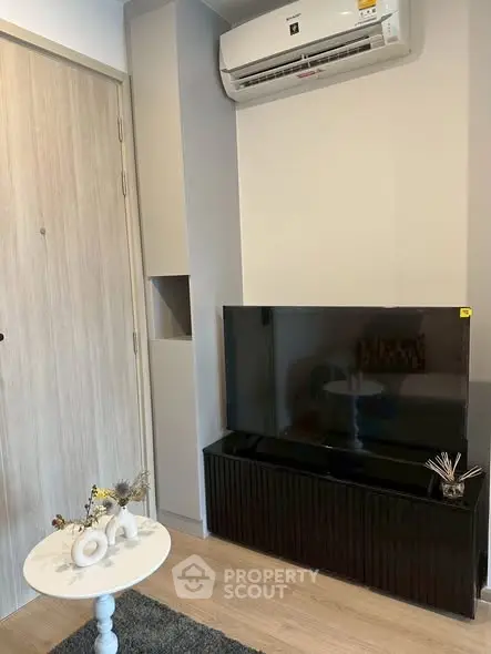 Modern living room with sleek TV setup and air conditioning unit, perfect for cozy relaxation.