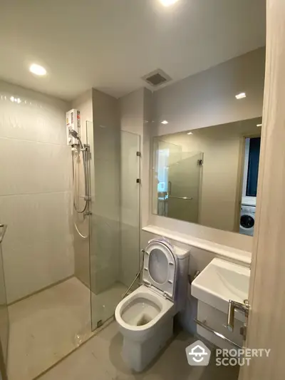 Modern bathroom with glass shower and sleek fixtures in contemporary apartment