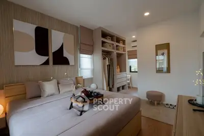 Modern bedroom with stylish decor and walk-in closet, featuring cozy bedding and elegant lighting.