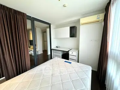 Spacious bedroom with modern furniture and large windows in a stylish apartment.