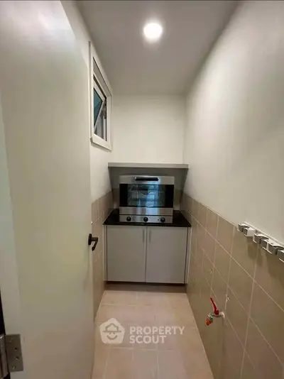 Compact kitchen with modern oven and sleek cabinetry in a cozy real estate unit.