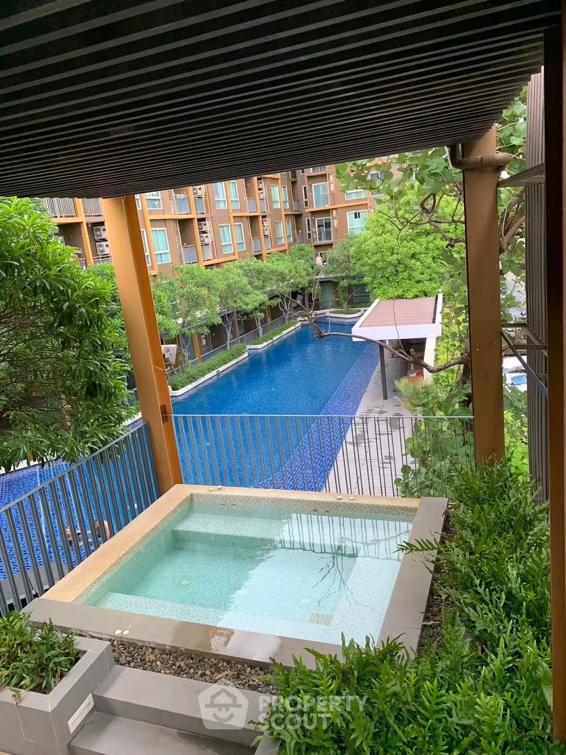 Luxurious apartment with private jacuzzi and stunning pool view, surrounded by lush greenery.