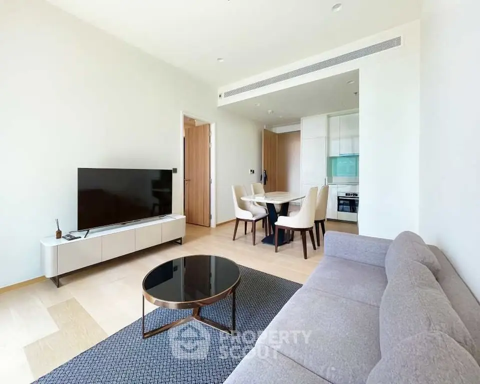 Modern living room with sleek furniture and open kitchen layout in a stylish apartment.