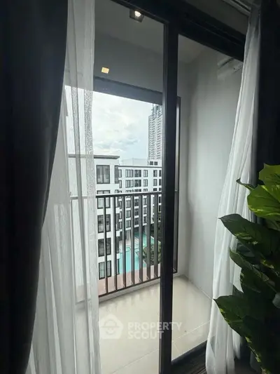 Modern apartment balcony with city view and pool, perfect for urban living.