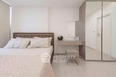 Modern bedroom with elegant decor and mirrored wardrobe in a stylish apartment.