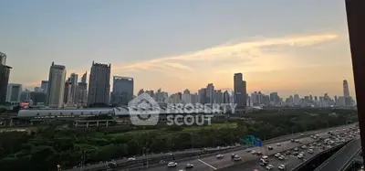 Stunning cityscape view from high-rise apartment with sunset backdrop.