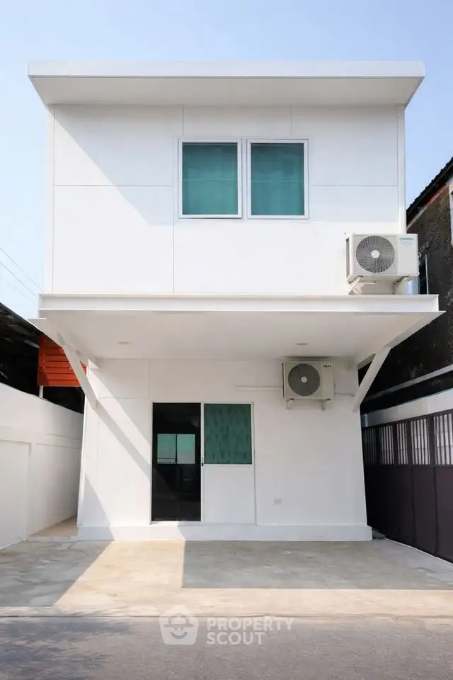 Modern minimalist two-story white house with air conditioning unit and driveway