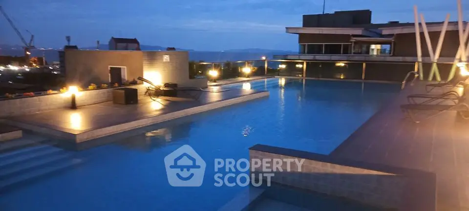 Luxurious rooftop pool with stunning city views at dusk, perfect for relaxation and entertainment.