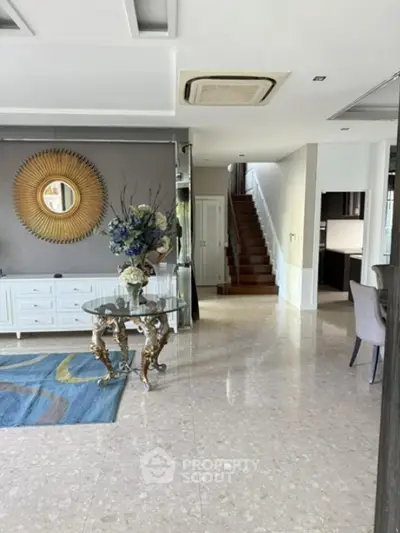 Elegant open living space with stylish decor and staircase, perfect for modern living.