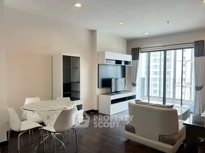 Modern living room with sleek furniture and balcony view in urban apartment.