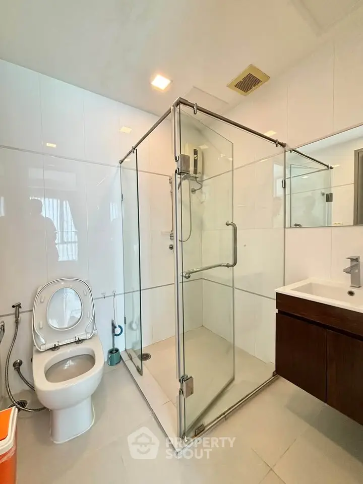 Modern bathroom with glass shower enclosure and sleek fixtures