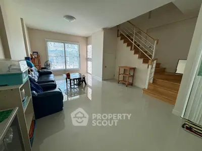 Spacious living room with modern staircase and natural light