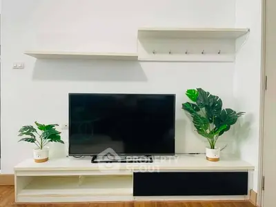 Modern living room with sleek TV stand and lush green plants enhancing decor.