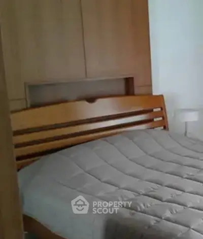 Cozy bedroom with wooden bed frame and modern design, perfect for relaxation.