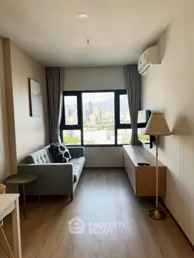 Modern living room with city view, featuring a cozy sofa, wall-mounted TV, and air conditioning.
