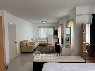 Spacious living room with cozy seating and natural light, perfect for relaxation.