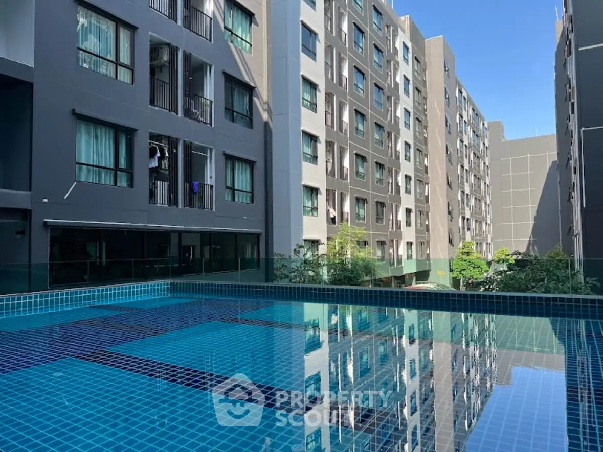 Modern apartment complex with a serene swimming pool and contemporary architecture.