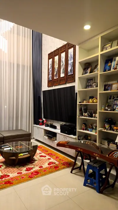 Luxurious living room with high ceilings, elegant decor, and modern entertainment setup.