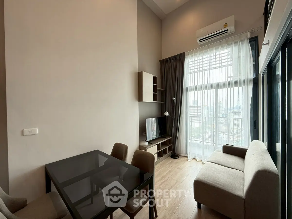 Modern living room with high ceiling and city view, featuring sleek furniture and large windows.