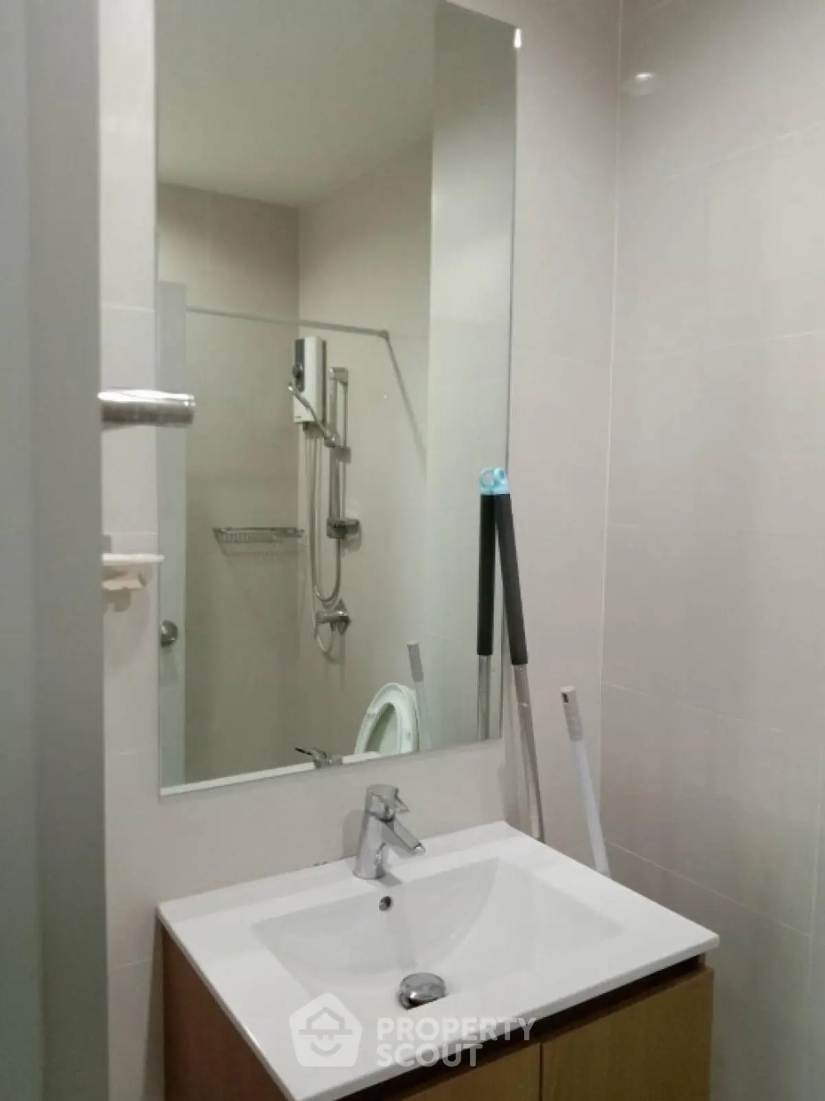 Modern bathroom with sleek sink and large mirror in a contemporary apartment.