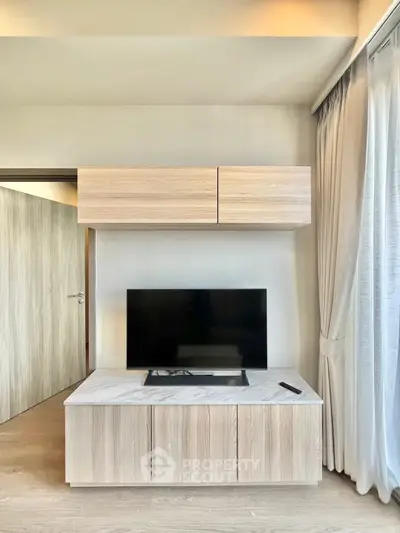 Modern living room with sleek TV unit and natural light