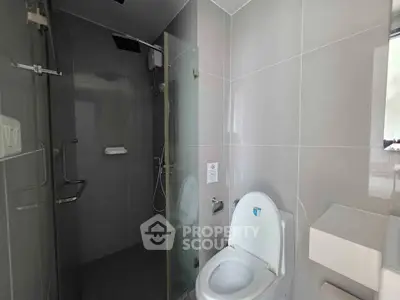 Modern bathroom with sleek design, featuring a glass shower and contemporary fixtures.