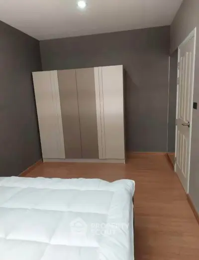Cozy bedroom with modern wardrobe and wooden flooring, perfect for a comfortable living space.