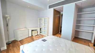 Spacious bedroom with modern furniture and ample storage in a stylish apartment.