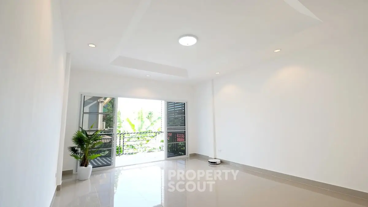Spacious living room with large windows and balcony access, perfect for natural light lovers.